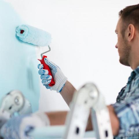 man-with-roller-painting-wall-blue